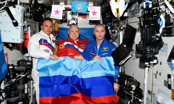 Российские космонавты с флагом ЛНР